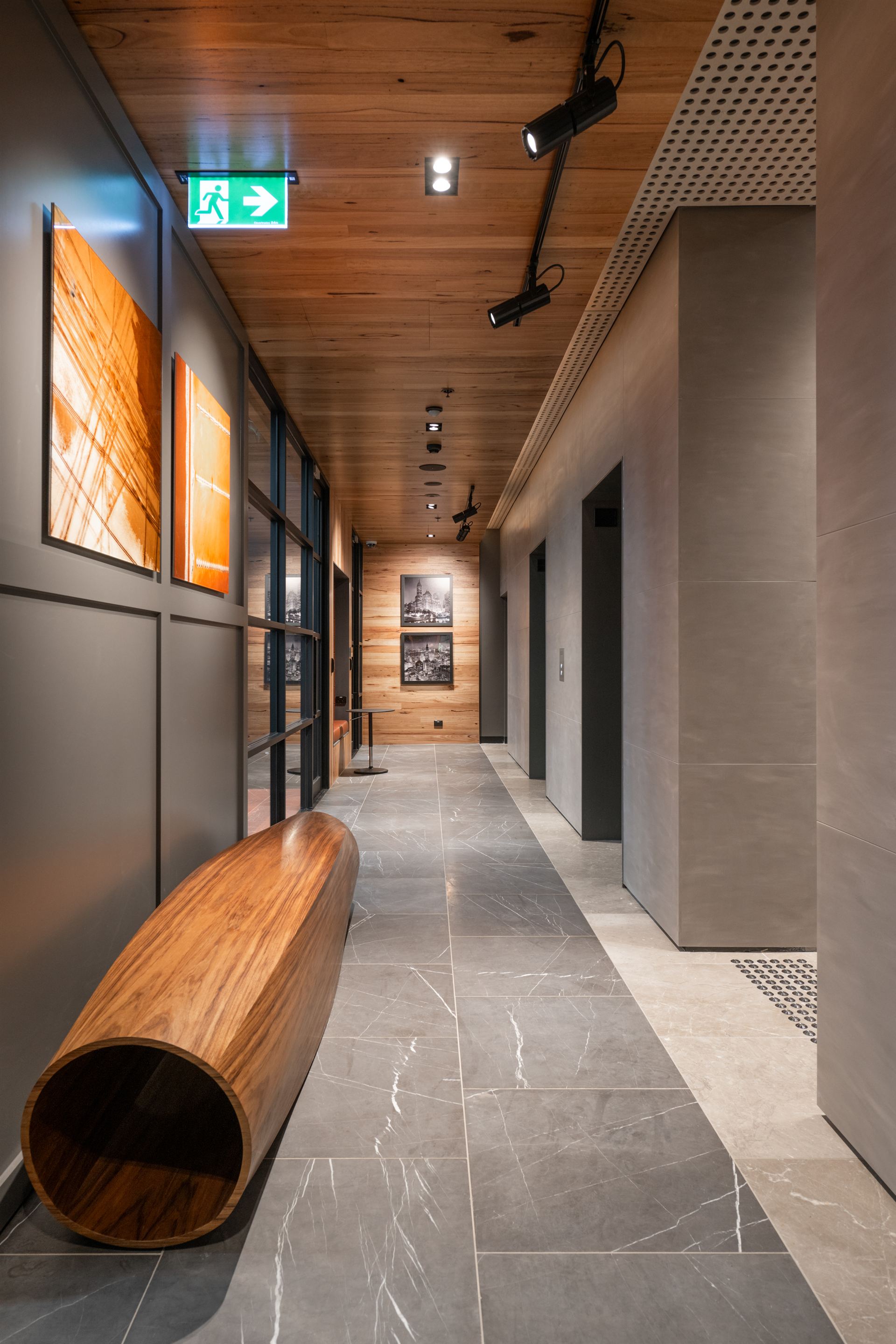 Lift lobby with timber ceiling and turned-log bench