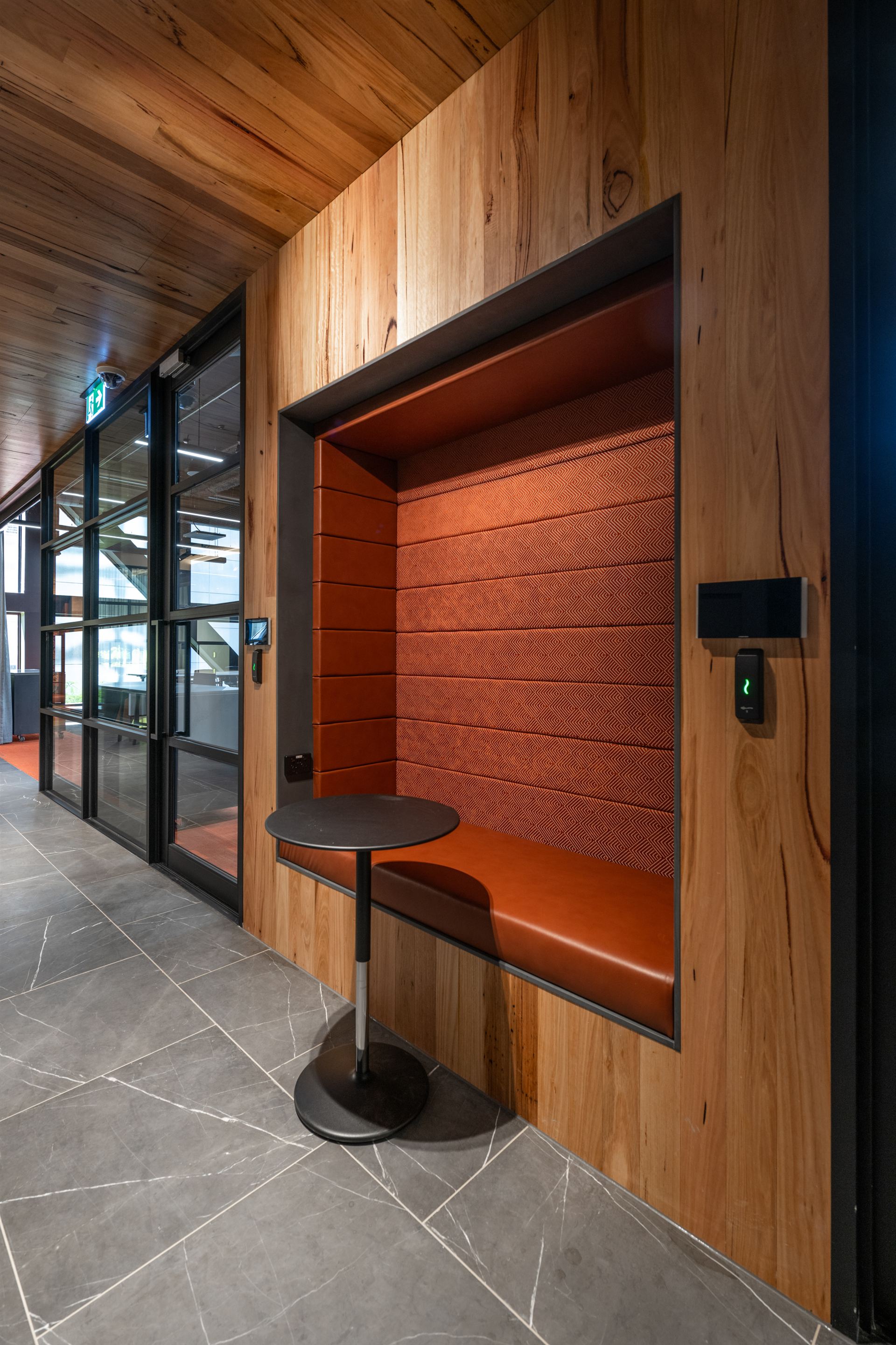 Upholstered booth nook set into the timber wall