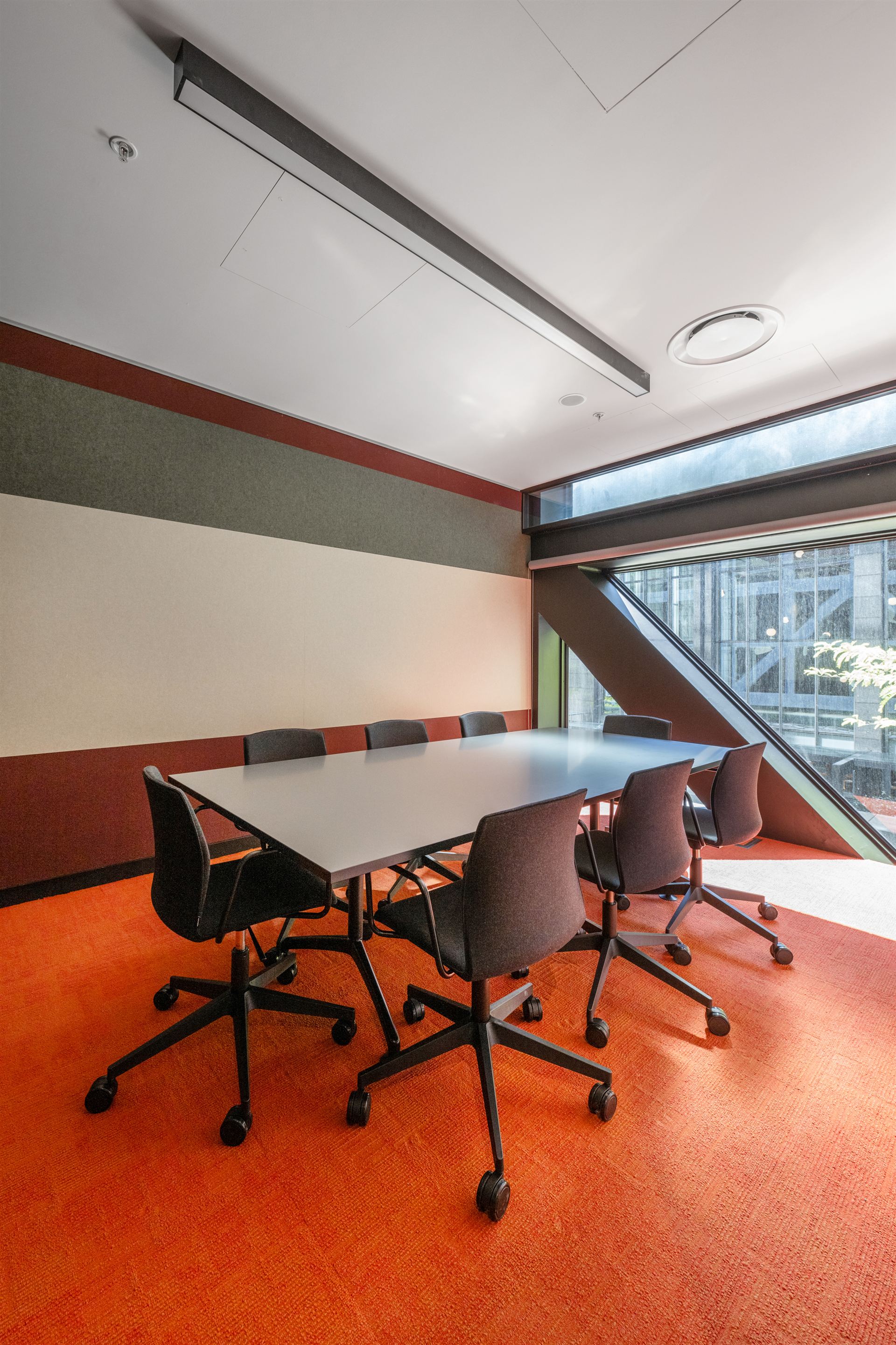 Level 5 meeting room with orange carpet and angled brace window
