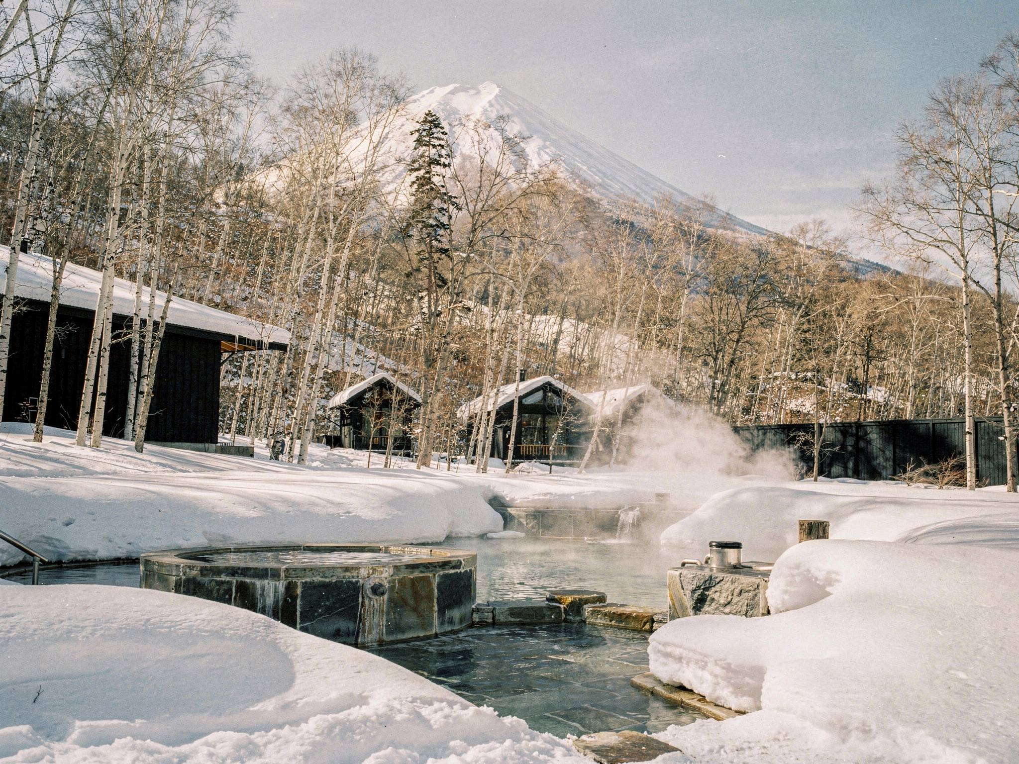 Steaming outdoor onsen pools edged in andesite stone