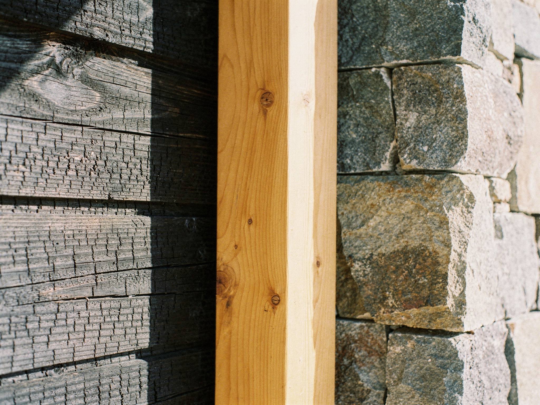 Material close-up of charred cedar texture beside glulam and stone