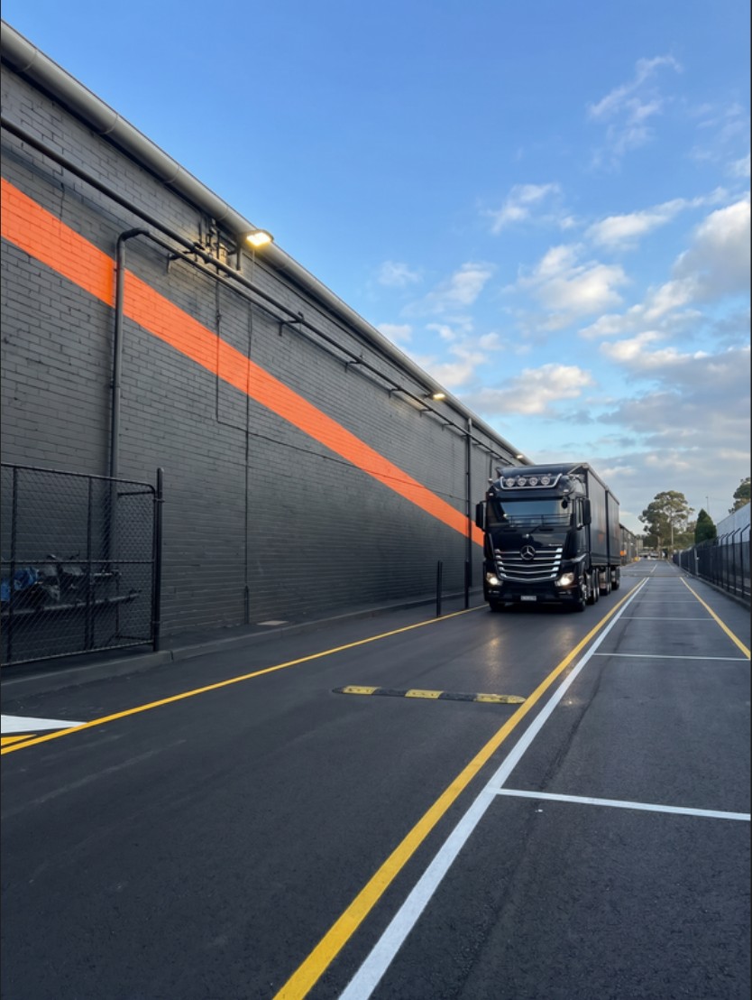 A truck passing the rebranded boundary wall at a Box Capital asset