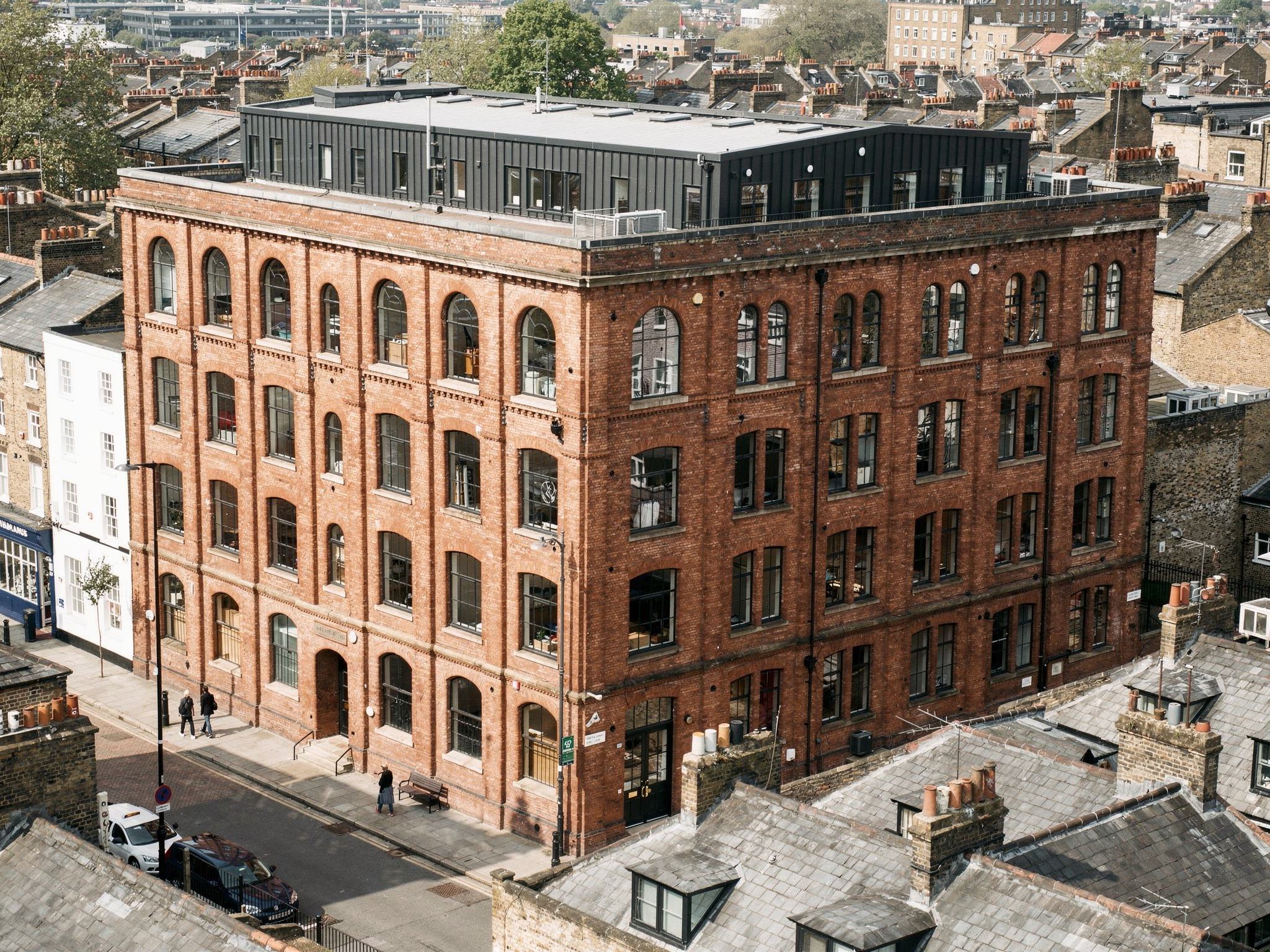 Aerial of the red-brick warehouse with a black-steel rooftop addition in London