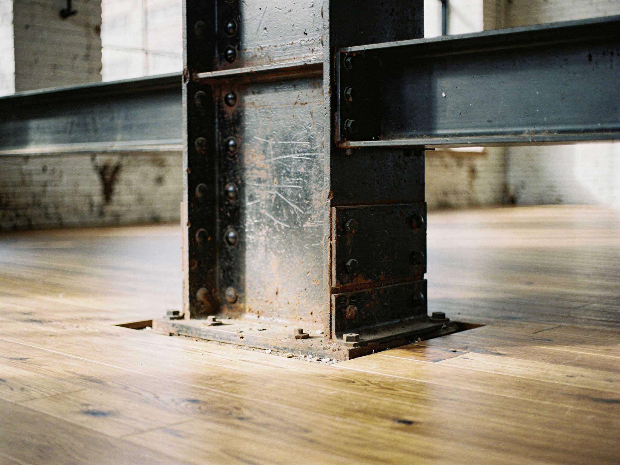 Detail of a cast-iron column meeting a blackened-steel beam and oak floor