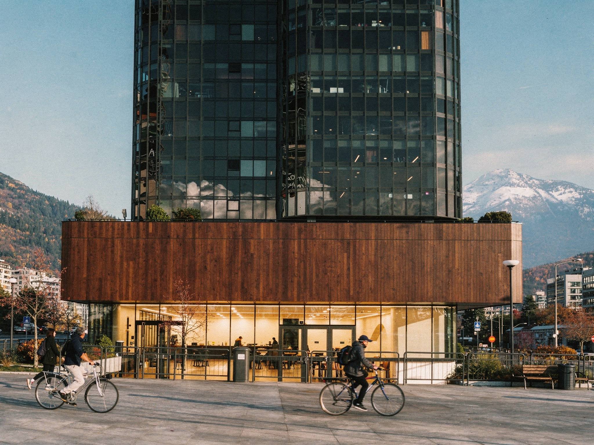 Mahogany timber podium and glowing lobby from the seawall promenade