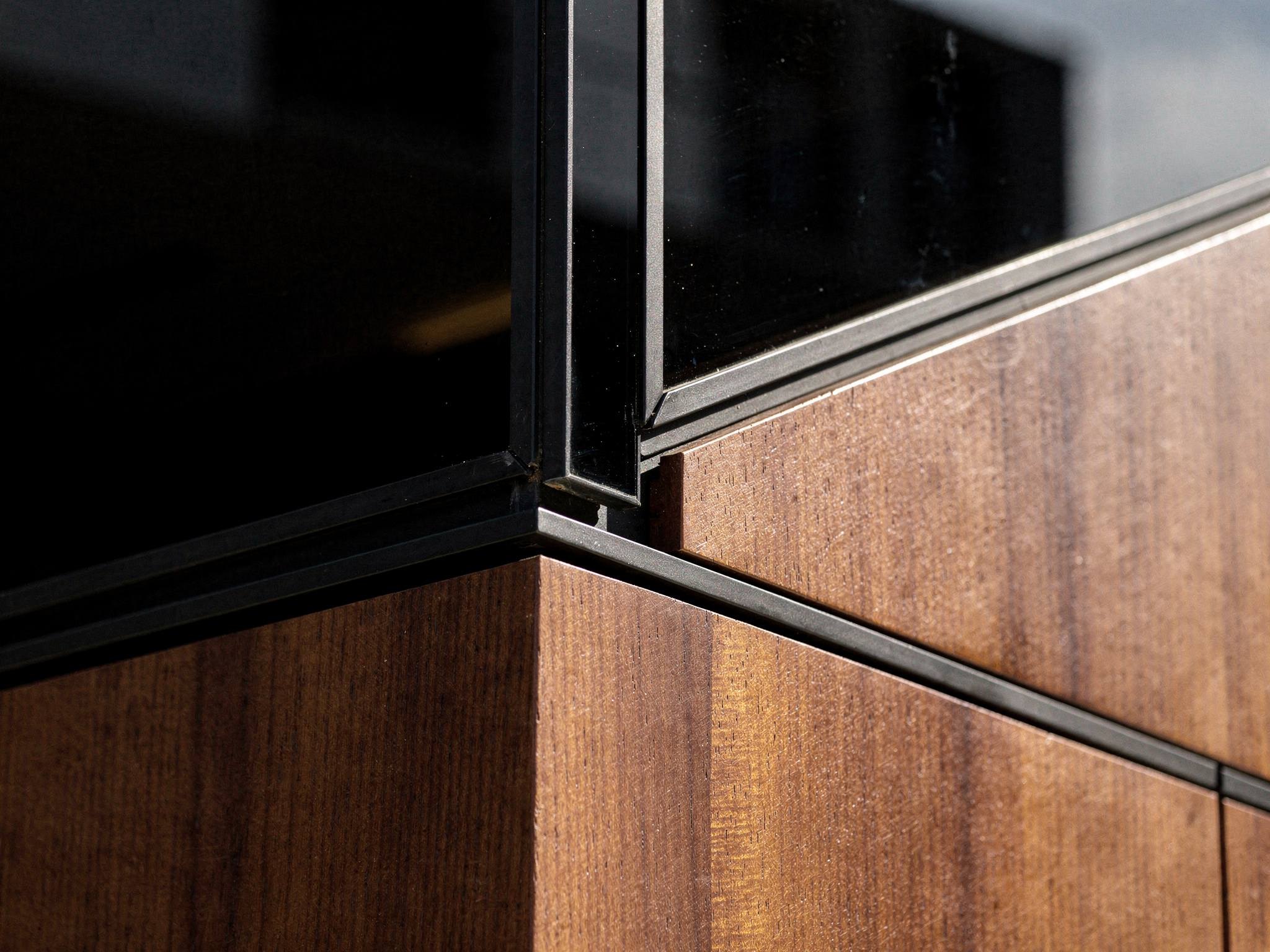Detail where the black glass curtain wall meets the mahogany timber podium