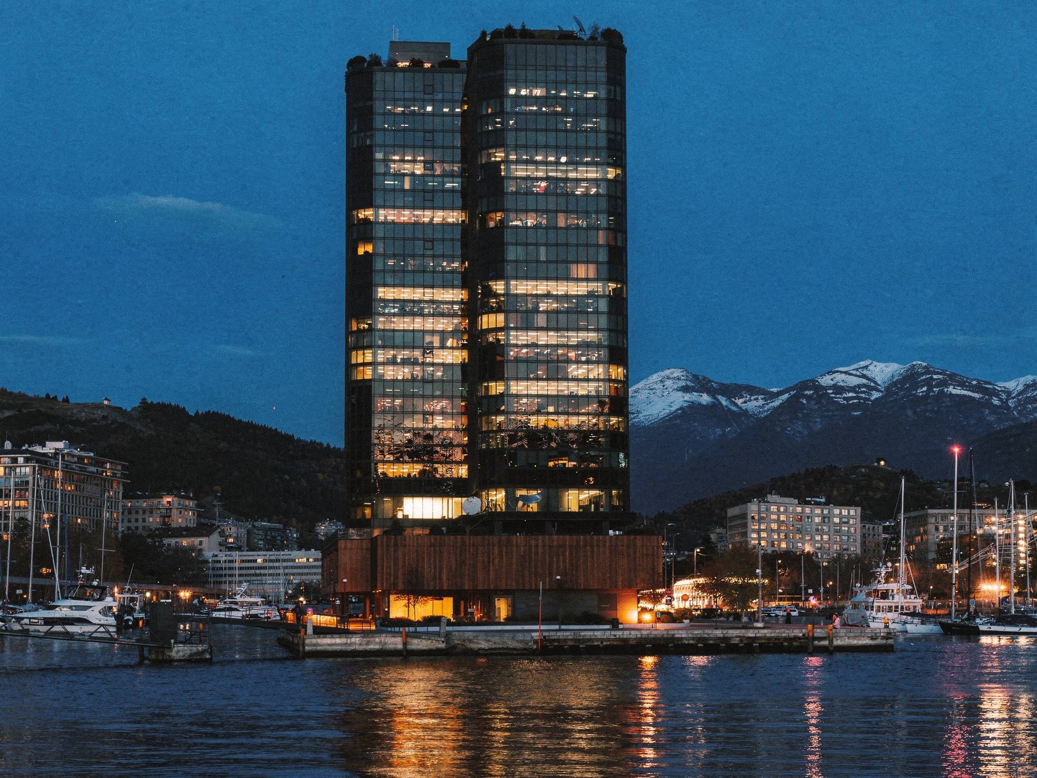 The tower at blue hour, offices glowing over the water