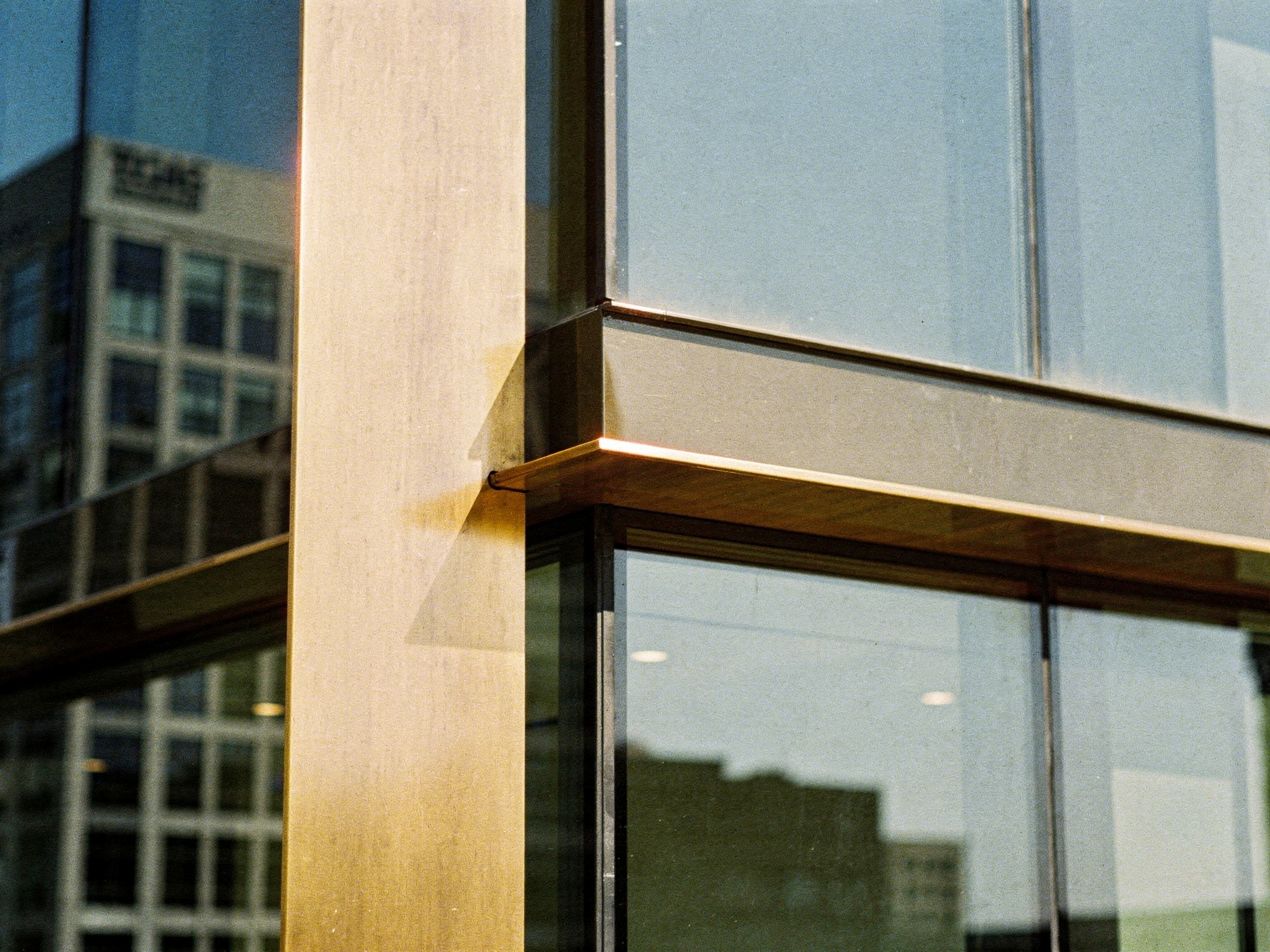 Detail of a bronze mullion meeting the glass curtain wall and spandrel