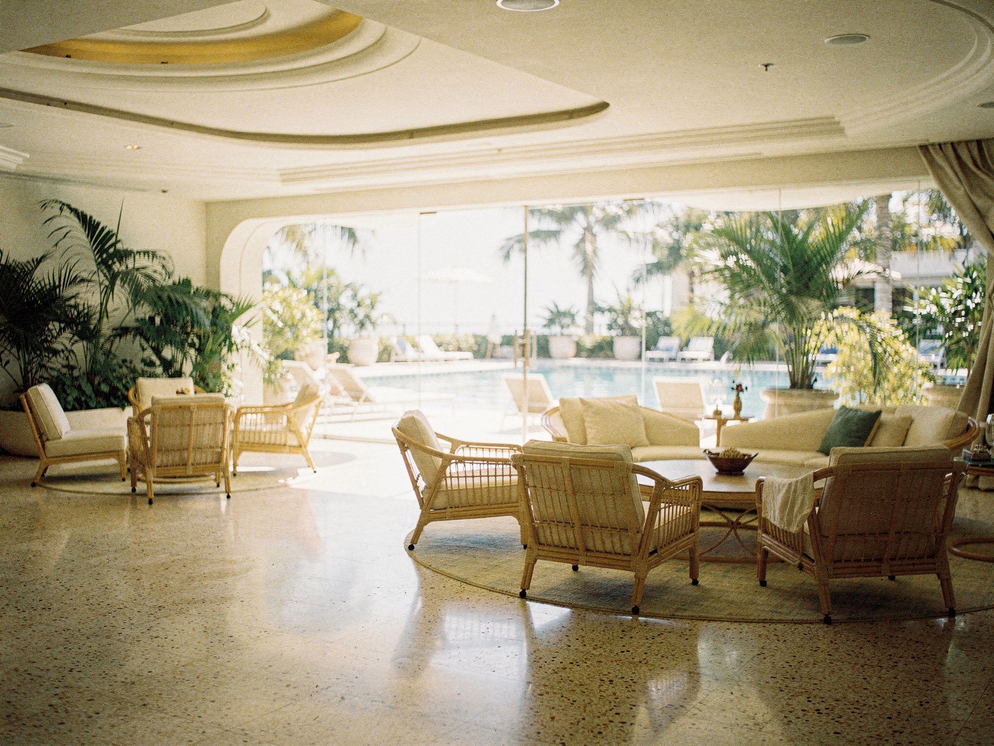 Double-height lobby with curved terrazzo desk and guests