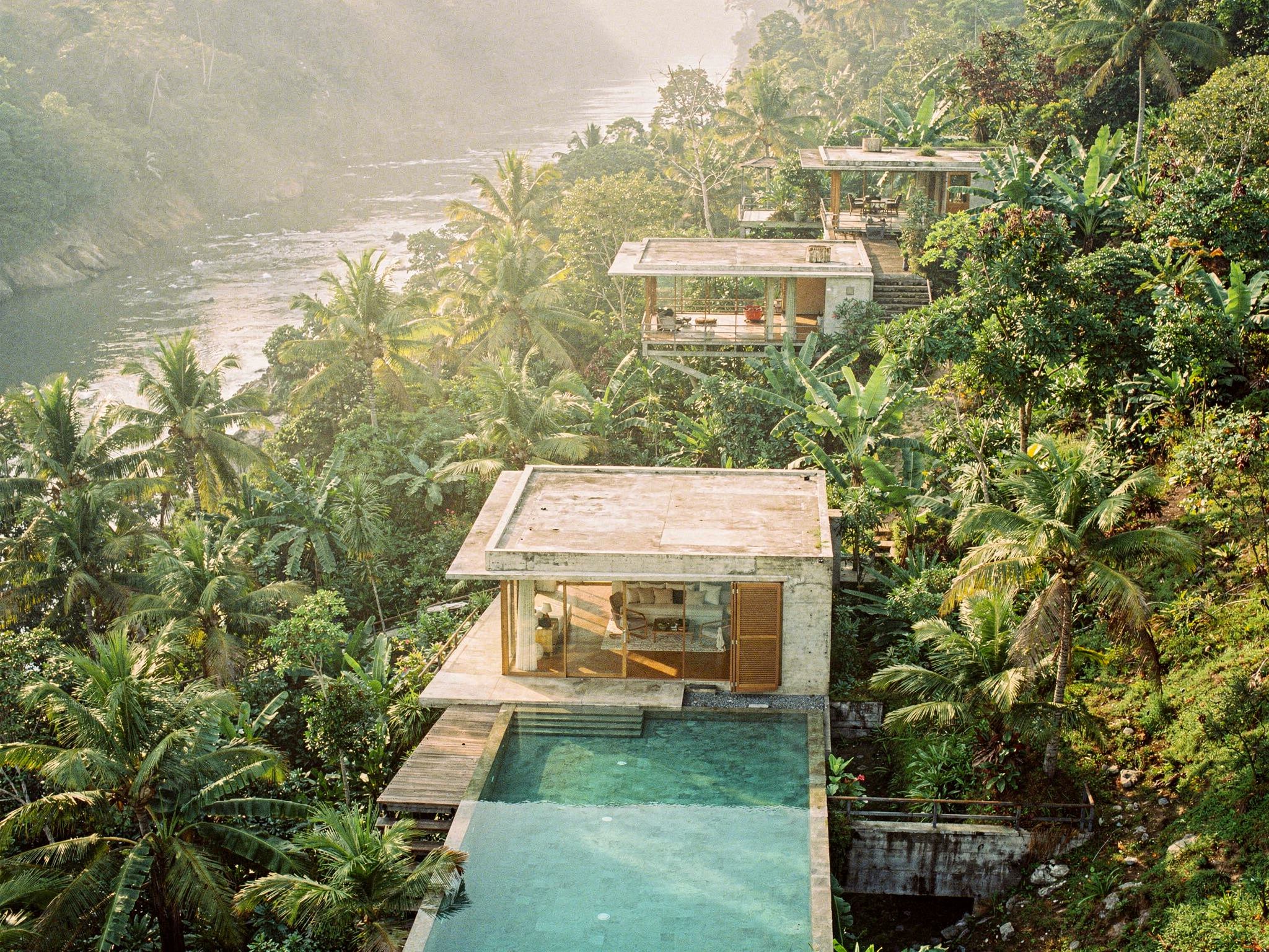 Aerial of the concrete-and-teak pavilions stepping down the jungle ravine to the river