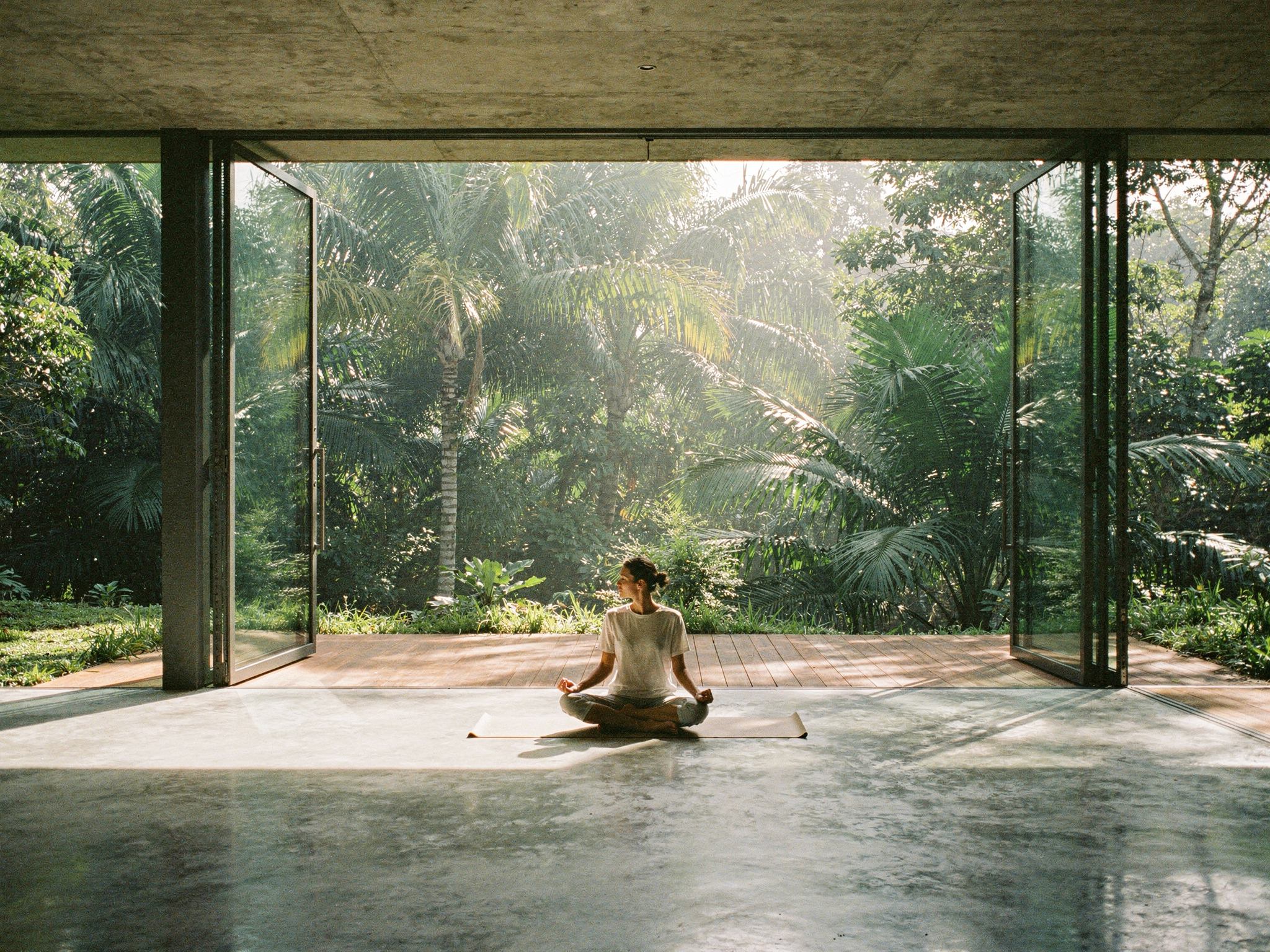 Seated meditation in the open concrete yoga pavilion facing the jungle