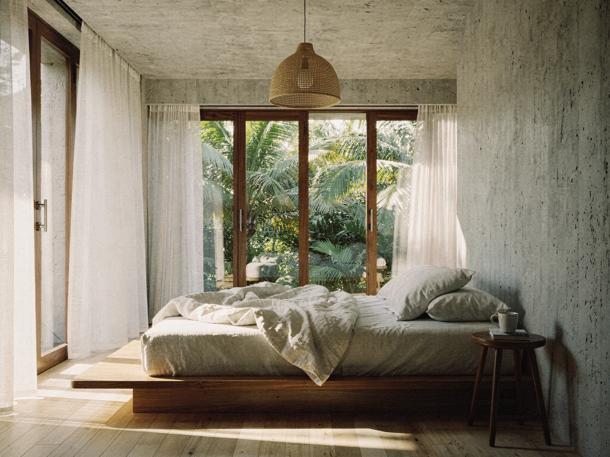 Suite with a low teak bed and concrete walls open to the palm ravine