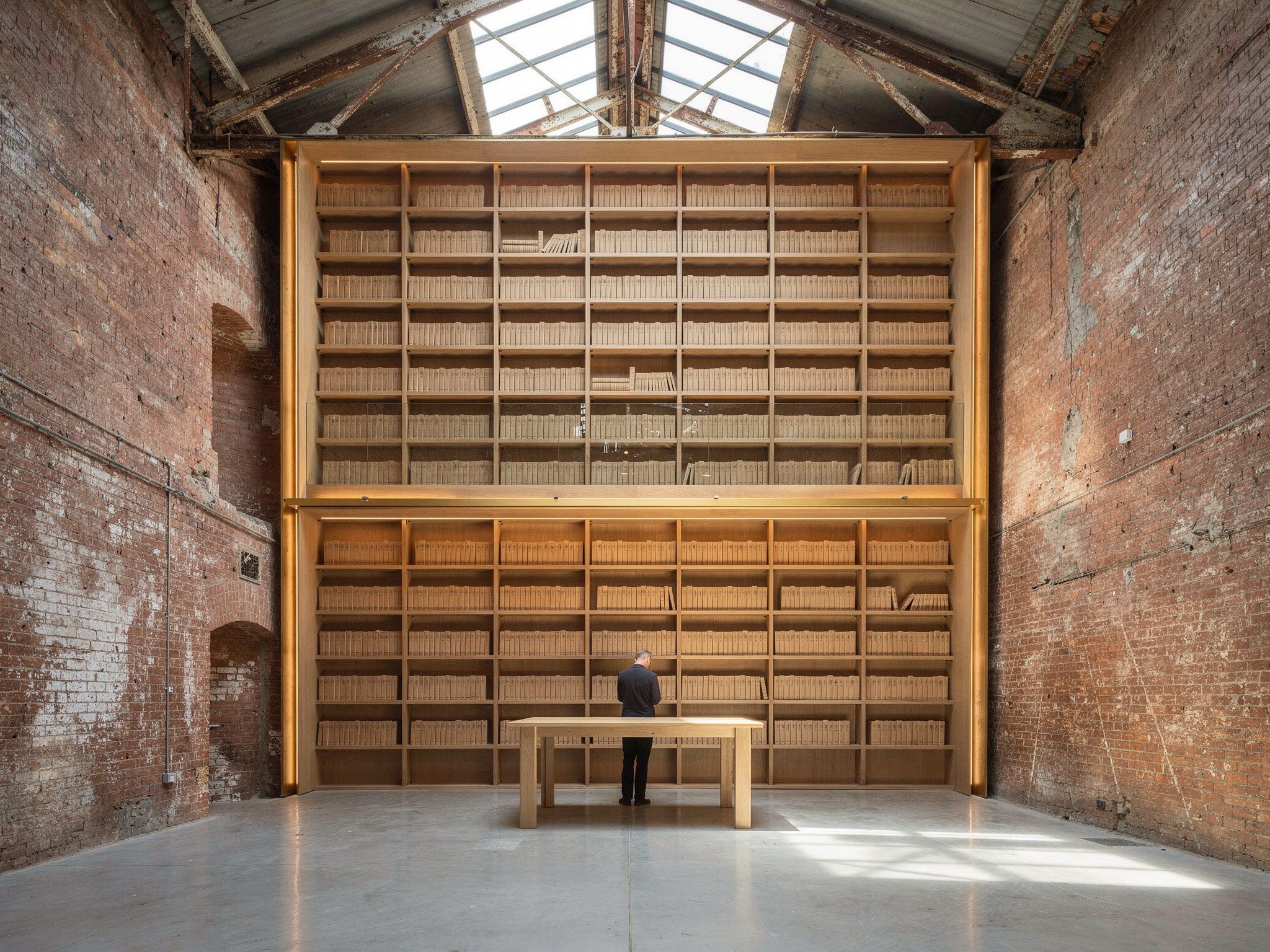 Bookshop with full-height oak shelving built as a free-standing insert inside the brick shell