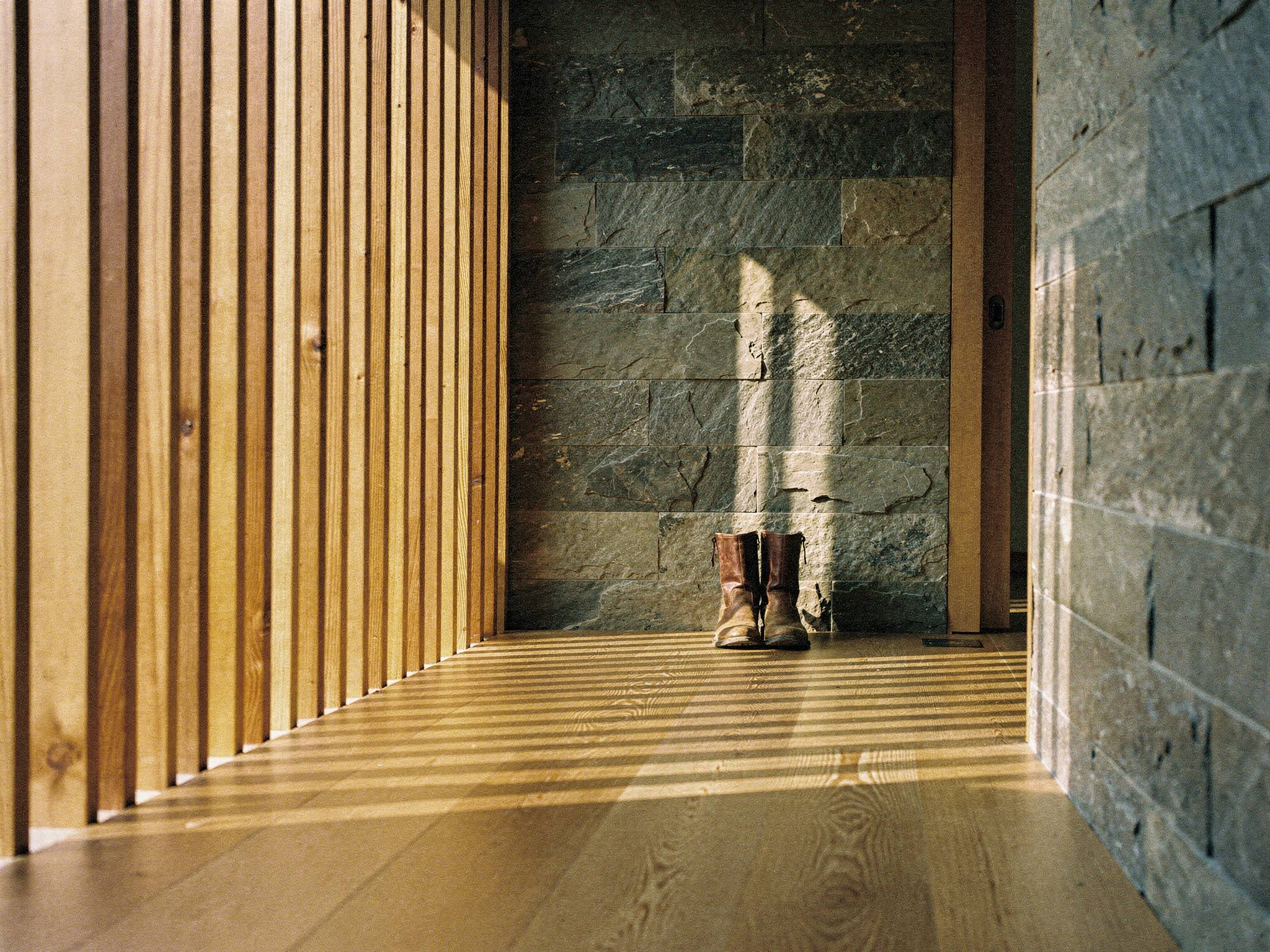 Cedar-batten screen raking afternoon light across the entry hall